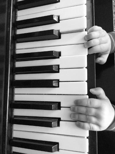 piano with toddler hands playing the keys.
