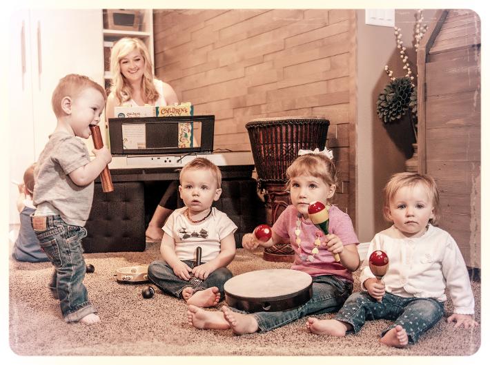 Alison Seipp teaching a music class to four babies/toddlers playing instruments.